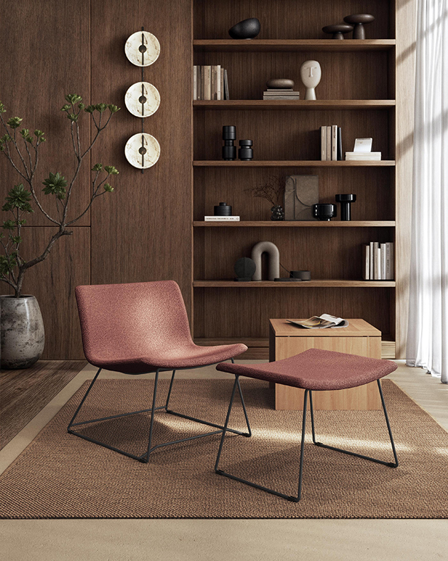 Chaises modernes en cuir rose avec un cadre en métal, devant une étagère en bois.